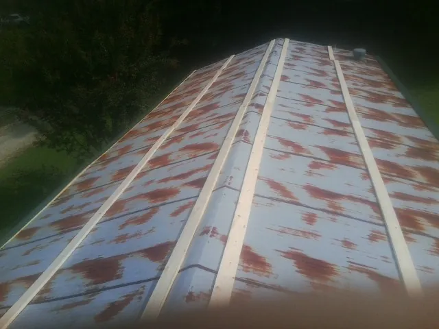Rusted metal roof panels with new wood purlins before replacement — Storm Damage Roof Repair in Kernersville by Roofing Brothers