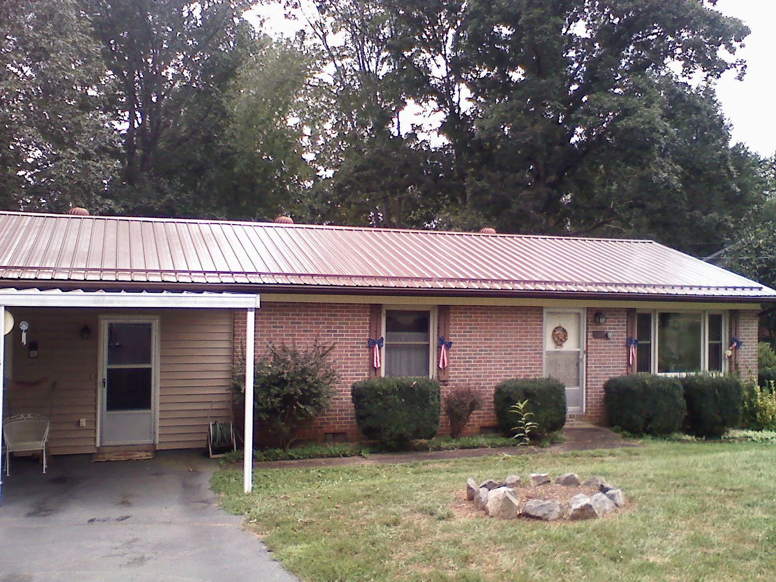 Bronze metal roof and carport on a brick ranch home — Roof Repair work by our crew in Kernersville