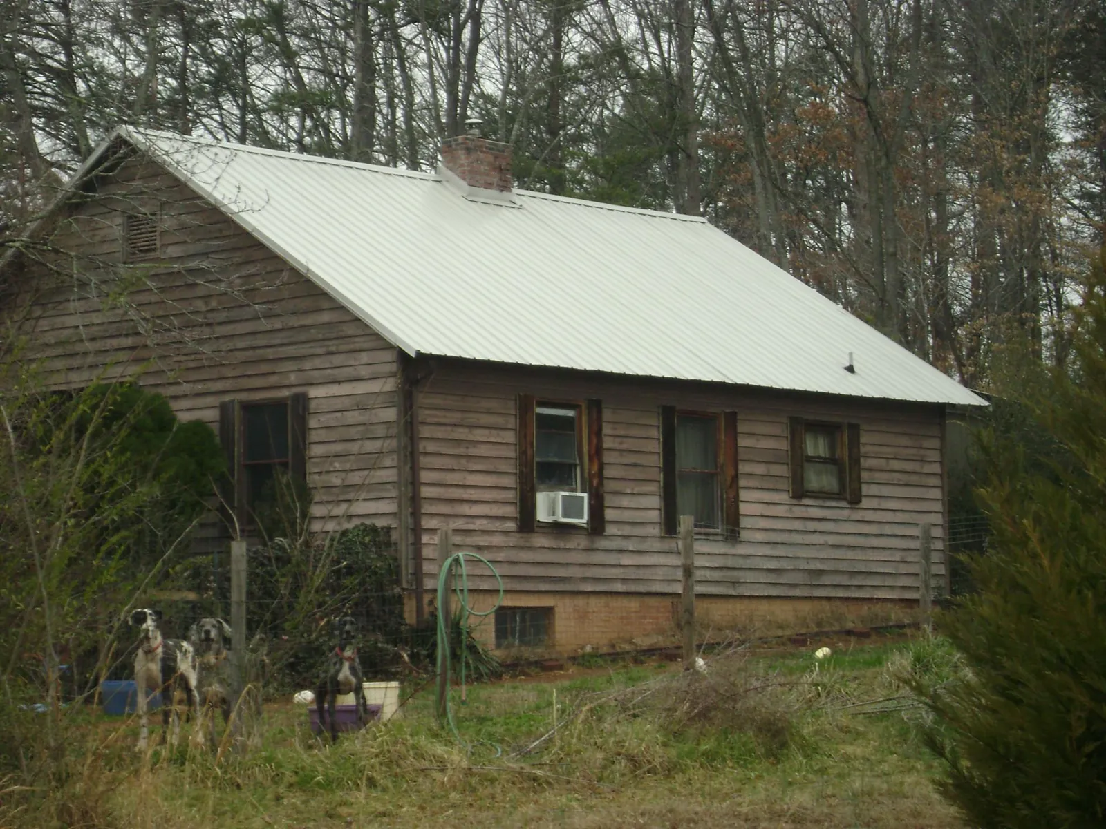 White metal roof on an old wood sided farmhouse, from a Metal Roof Installation job in Kernersville